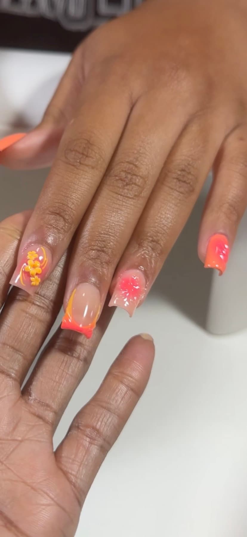 Coral and orange coffin extensions with sculpted 3D flowers and encapsulated floral detail