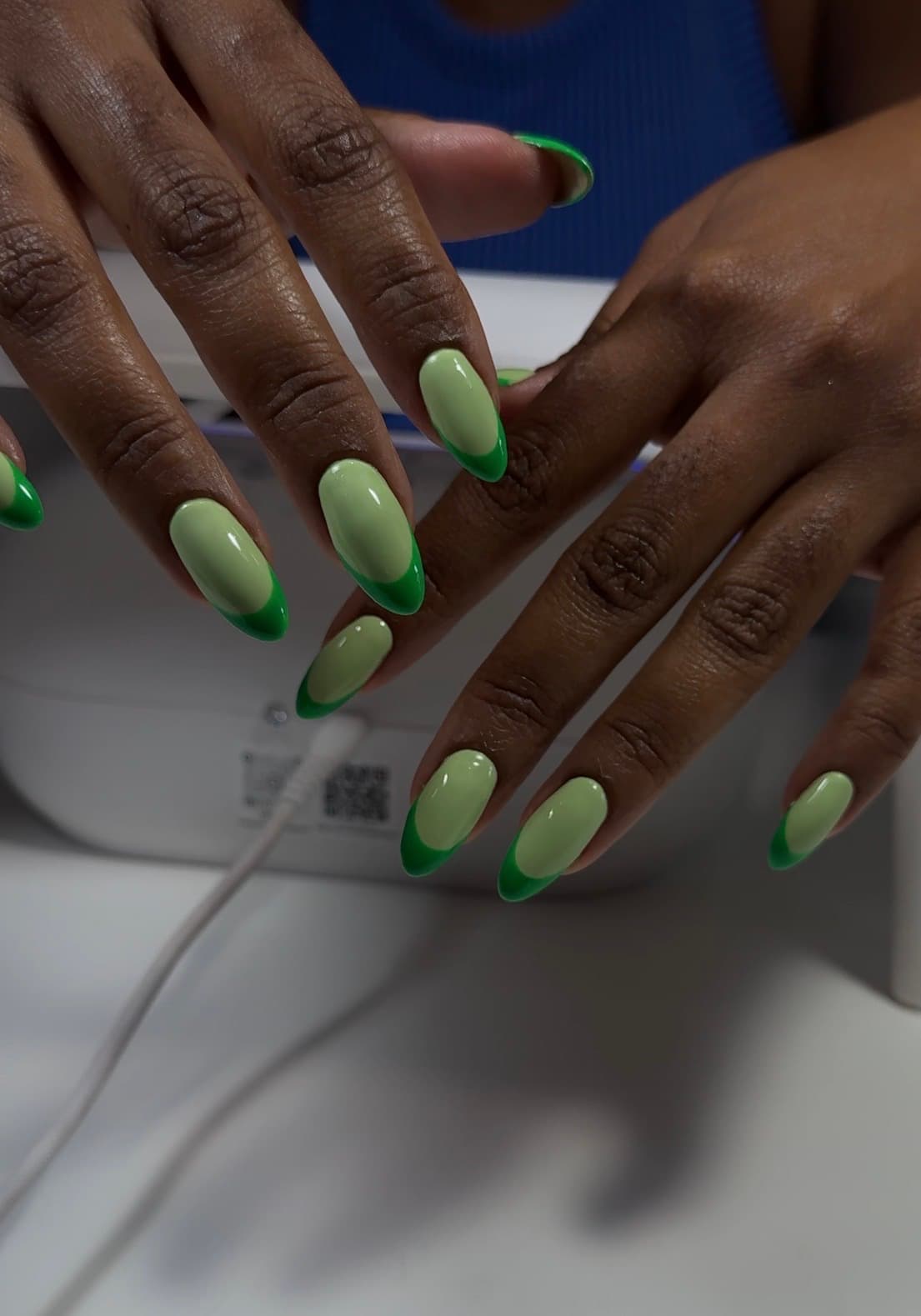 Almond gel nails in soft pistachio with a deep green French tip