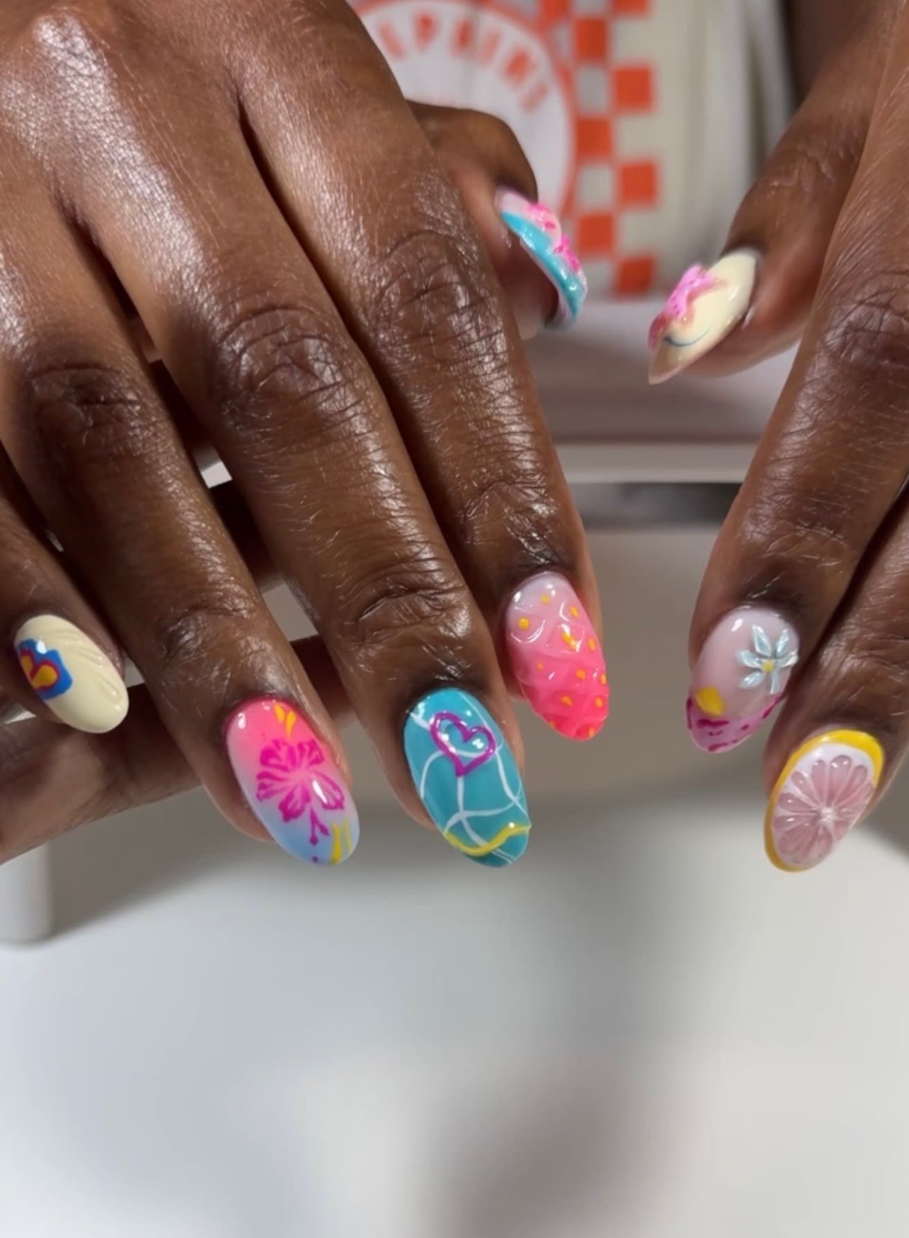 Full set of almond nails hand-painted with hibiscus flowers, citrus slices, hearts and 3D floral detail